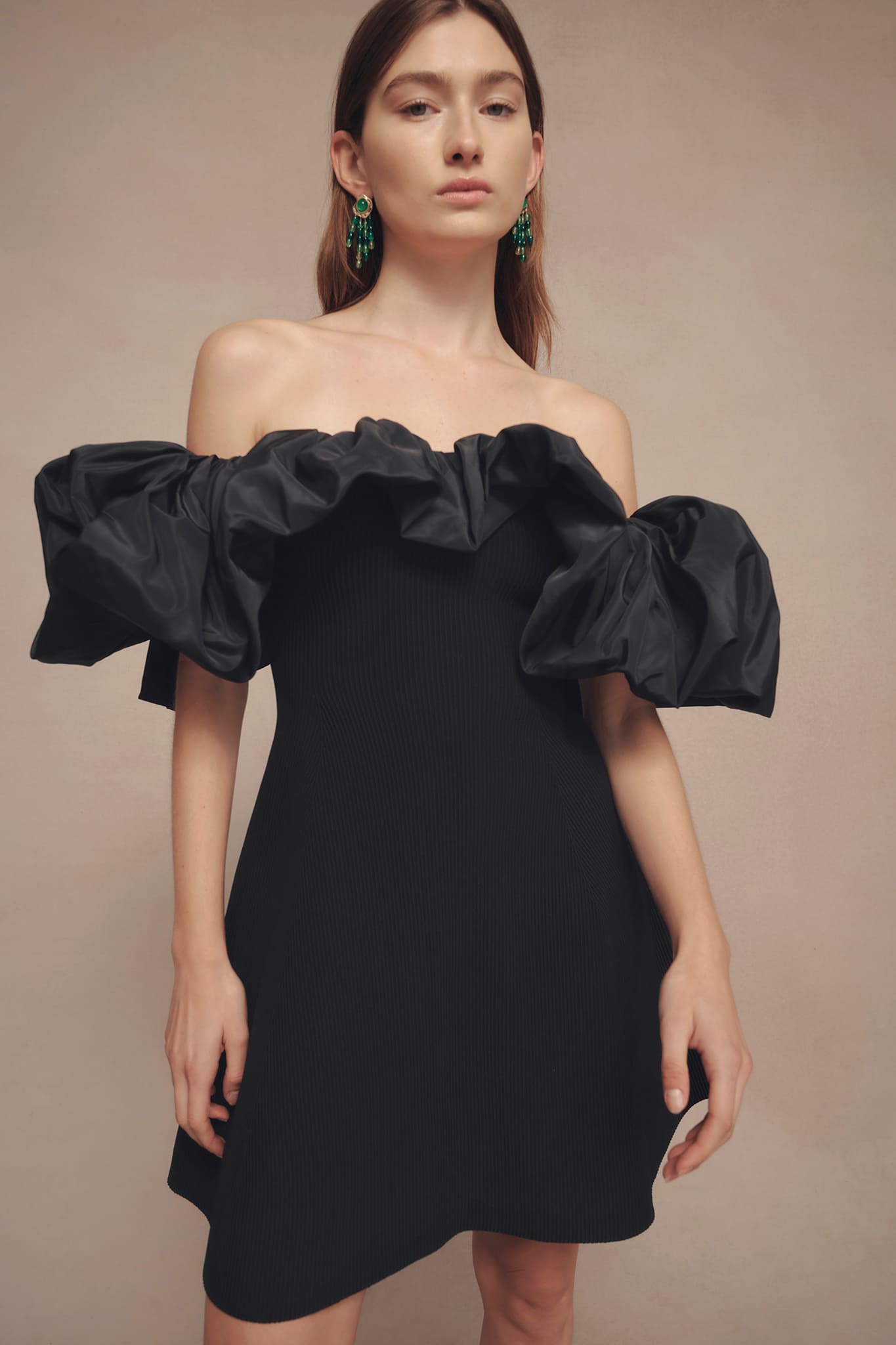 Woman wearing Eldora Mini Black Dress from Aje with fitted waist and flared skirt, featuring controlled volume puff neck and sleeve, achieved through a woven elasticated design.